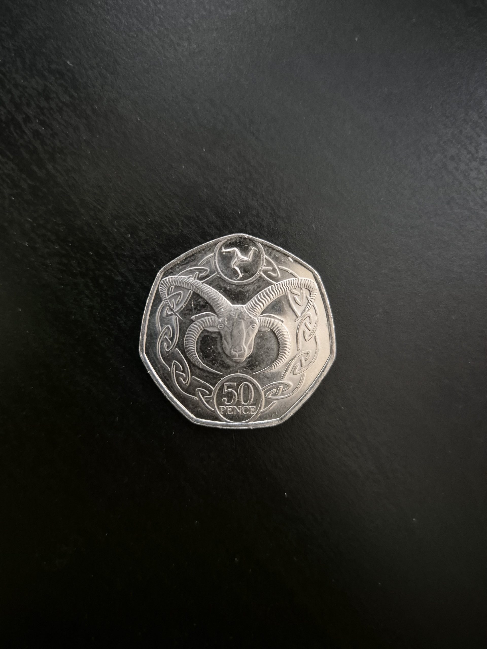 2020 Isle of Man 50p Manx Loaghtan Sheep Coin - Rare Collector's Item Image of a 2020 Isle of Man 50 pence coin featuring a Manx Loaghtan sheep within a Celtic knot design. The coin is silver-colored and displayed against a dark background.