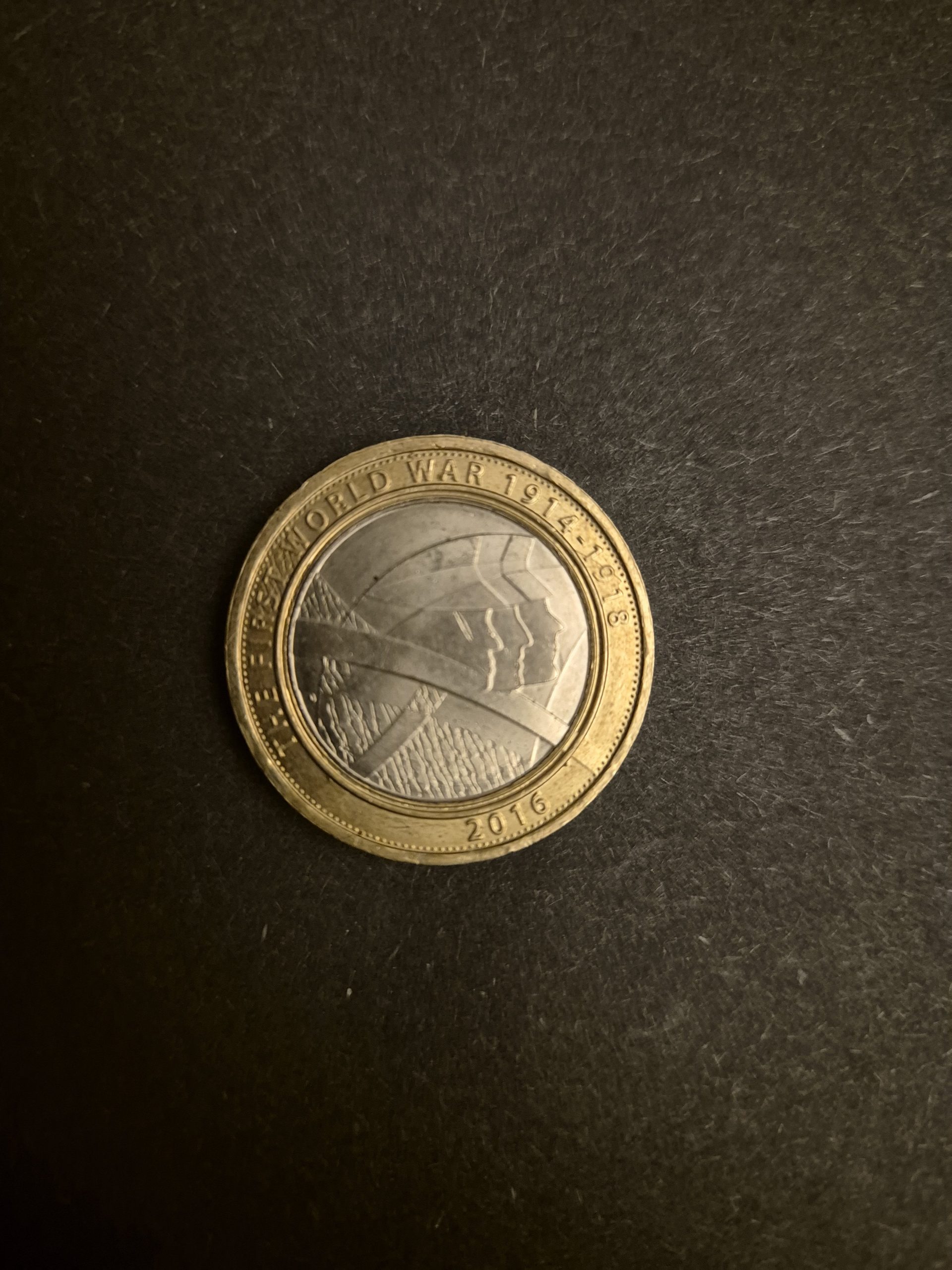 2016 First World War Commemorative £2 Coin - UK Currency A 2016 UK £2 coin commemorating the First World War, featuring a design of soldiers' silhouettes.